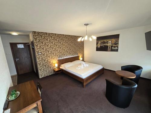1 dormitorio con 1 cama, mesa y sillas en Penzión Arizona, en Zlaté Moravce