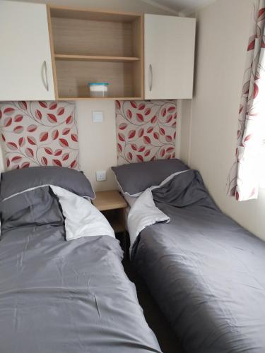 two beds sitting next to each other in a room at Cordy's Caravan in Mablethorpe