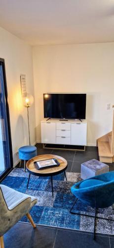 un salon avec une grande télévision à écran plat dans l'établissement LE COTTAGE, à Séné