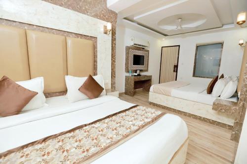 a hotel room with two beds and a television at Airport Plazzo Crown Haven Delhi in New Delhi