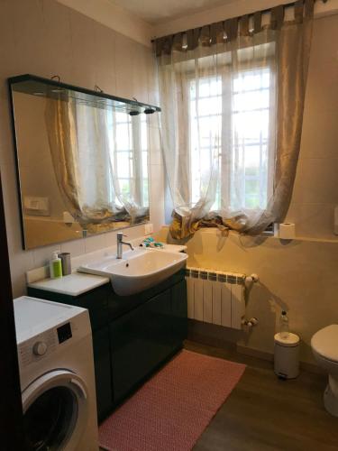 San Vito al Torre的住宿－DIMORA IL CAMMINO，一间带水槽和洗衣机的浴室