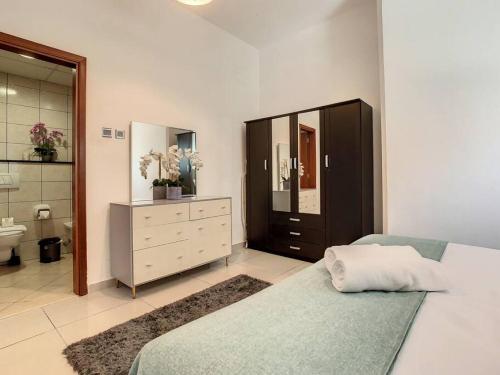 a bedroom with a bed and a dresser and a bathroom at Key View - Marina Pinnacle in Dubai