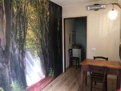 a dining room with a large mural of trees on the wall at DIMORA IL CAMMINO in San Vito al Torre