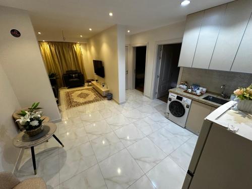 a large kitchen with white tile flooring and appliances at Roma house in Al Madinah