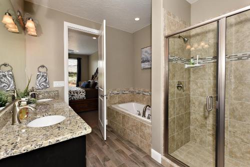 a bathroom with a shower and a sink and a tub at Escape On The 18th Hole in St. George