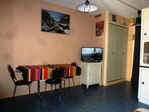 Cette chambre dispose d'une télévision et d'une table avec des chaises. dans l'établissement Résidence Le Lys - Studio 4 Personnes MAE-4135, à Cauterets