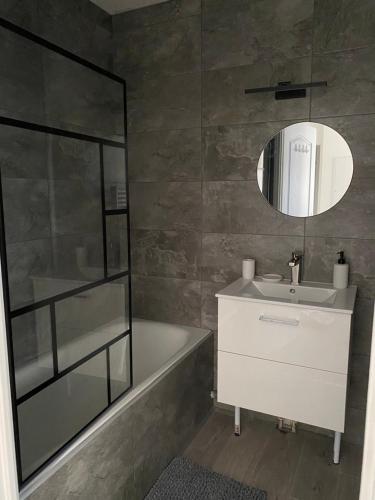 une salle de bain avec un lavabo et un miroir dans l'établissement Appartement cosy agde, à Agde