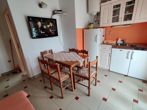 a kitchen with a table and chairs and a refrigerator at Apartmani Petković in Zaboric