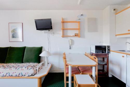 un salon avec un canapé et une table dans l'établissement Résidence Le Hameau du Sauget - maeva Home - Studio 4 Personnes Confort MAE-4377, à La Plagne Tarentaise