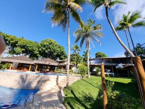 a resort with palm trees and a swimming pool at Paraíso Tropical desejado Centro de Arraial in Arraial d'Ajuda