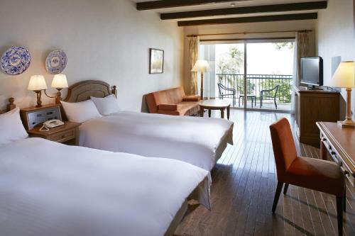 志摩市にある都リゾート 志摩 ベイサイドテラスのベッド2台とバルコニーが備わるホテルルームです。