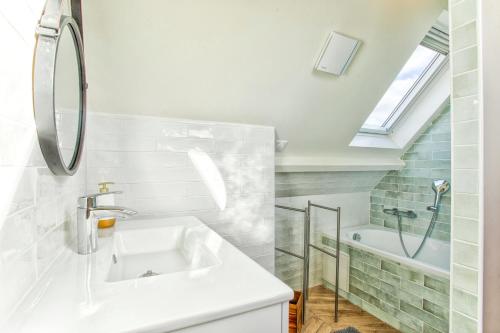 a white bathroom with a sink and a shower at Maison Victoria Cabourg in Cabourg