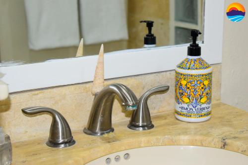 a sink with a bottle of soap next to a mirror at Marina Pinacate B-408 in Puerto Peñasco