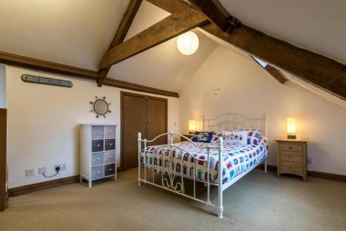 a bedroom with a bed and a wooden ceiling at Shell Cottage - 2 Bedroom Holiday Home - Tenby in Tenby