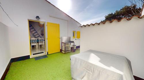 a room with a green floor and a yellow door at Etoile de mer avec piscine in Brétignolles-sur-Mer