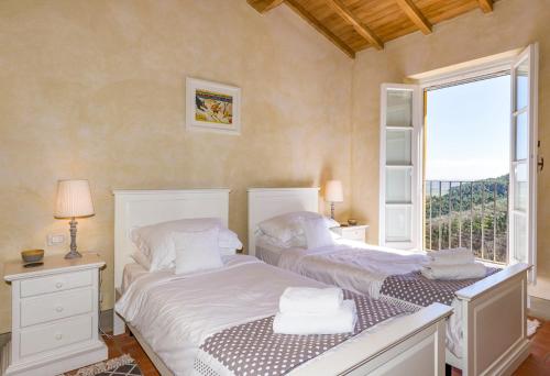 twee bedden in een kamer met een raam bij Casale Mola in Capannori