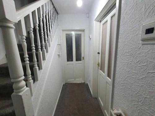 a white hallway with a white door and stairs at Double Bedroom WD Greater Manchester in Middleton