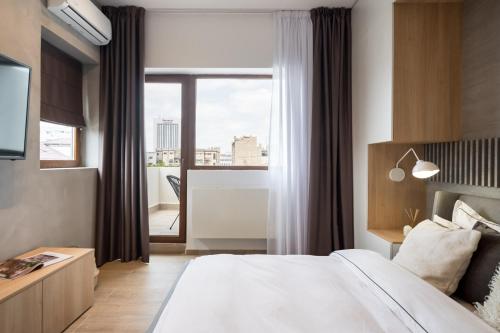 a bedroom with a large bed and a large window at Pitar Mos - Downtown Bucharest in Bucharest