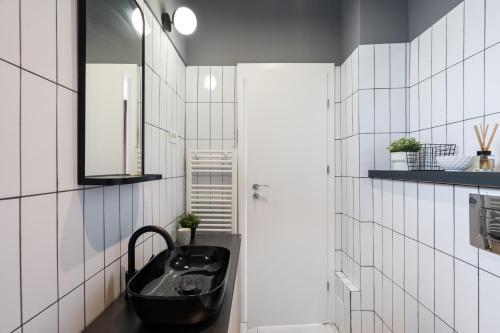 a bathroom with a black sink and a mirror at Pitar Mos - Downtown Bucharest in Bucharest