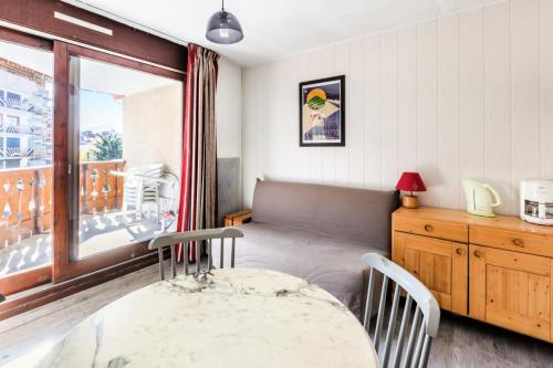 une salle à manger avec une table et un balcon dans l'établissement Studio 4 pers. pied des pistes - maeva Home - Studio 4 Personnes Sélection MAE-9059, à L'Alpe-d'Huez