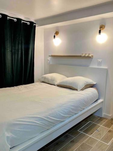 une chambre avec un lit avec deux oreillers dessus dans l'établissement Appartement charmant proche de Paris, à Villemomble