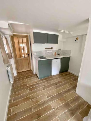 Il comprend une cuisine avec un comptoir et du parquet. dans l'établissement Appartement charmant proche de Paris, à Villemomble