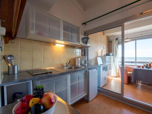 a kitchen with a table with a bowl of fruit at Studio Marina 2-1 by Interhome in Saint-Cyprien-Plage