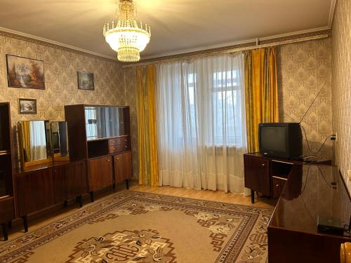 a living room with a television and a chandelier at Недорога квартира на Харківській, 32 in Sumy
