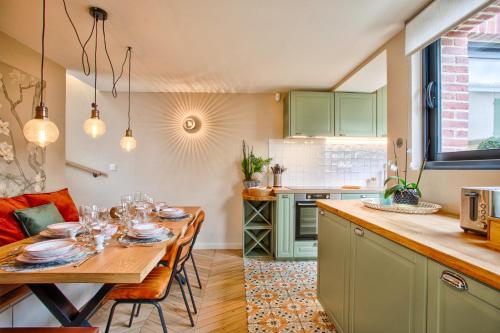 une cuisine avec une table avec des verres à vin dessus dans l'établissement Maison Victoria, à Cabourg