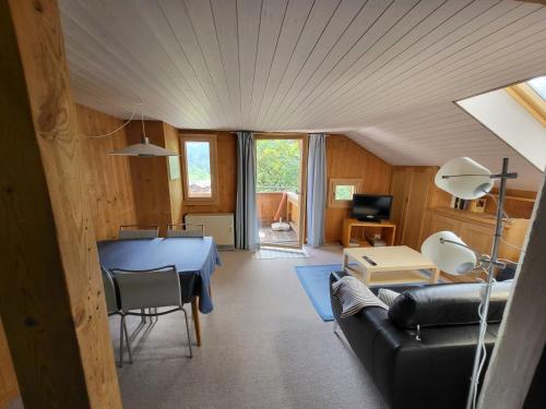 ein Wohnzimmer mit einem Sofa und einem Tisch in der Unterkunft Apartment Wildbach in Lenk im Simmental
