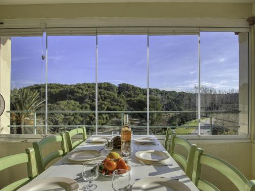 ein Esszimmer mit einem Tisch und einem großen Fenster in der Unterkunft Apartment Les Rivages de Coudoulière-2 by Interhome in Six-Fours-les-Plages