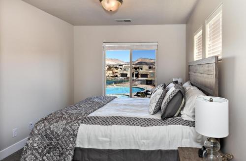 a bedroom with a bed with a view of a pool at Eagle's Ledge in St. George