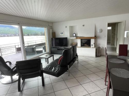 ein Wohnzimmer mit einem Tisch, Stühlen und einem TV in der Unterkunft Holiday Home Seestern direkt am See by Interhome in Ennetbürgen