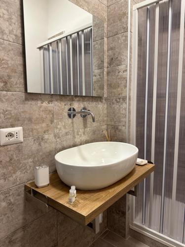 een badkamer met een witte wastafel en een spiegel bij Casa Ivana in Norma