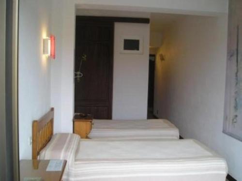 a room with three beds in a room with a door at Hostal Can Jordi in Cala Figuera