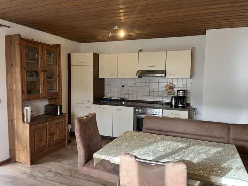 una cucina con tavolo e una cucina con armadietti bianchi di Holiday Home Billerhof by Interhome a Zachenberg