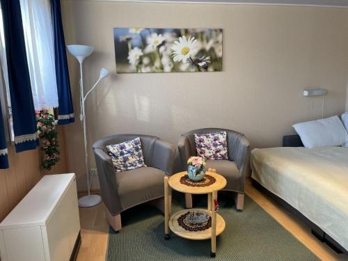a hotel room with a bed and two chairs and a table at Apartment Old Hüsung - MUZ322 by Interhome in Mirow