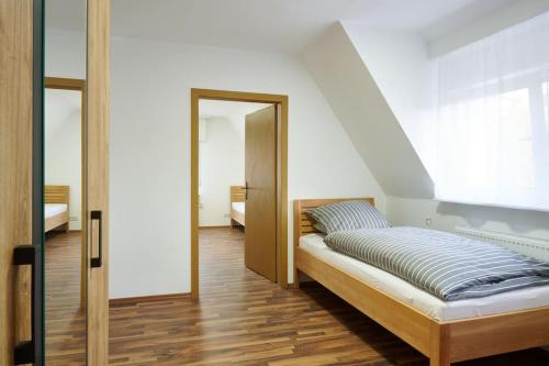 麥納茲哈根的住宿－Meinerzhagen - Schöne Unterkunft mit Kamin，一间卧室设有一张床、一个窗口和一面镜子