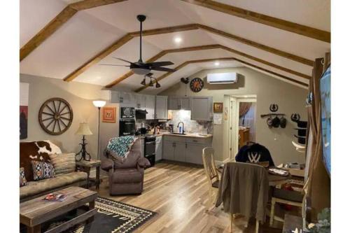 a living room with a ceiling fan and a kitchen at Stockyards-Walk 1 Block to StockYards-Cowboy Cabin in Fort Worth