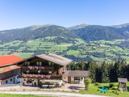 a house on a hill with mountains in the background at Holiday Home Umbichl by Interhome in Uttendorf