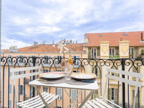 - une table avec 2 verres à vin sur le balcon dans l'établissement Apartment Foncet by Interhome, à Nice