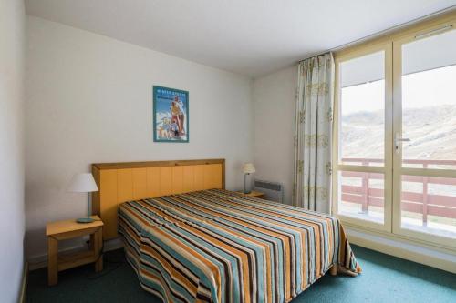 une chambre avec un lit et une grande fenêtre dans l'établissement Résidence Le Montana - maeva Home - 2 pièces 8 Personnes Confort MAE-9426, à La Mongie