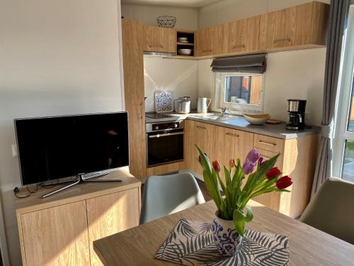 a kitchen with a table with a vase of flowers on it at Holiday Home Tiny Haus Motte by Interhome in Wemding