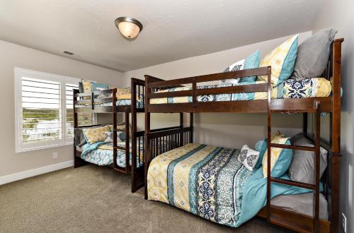 a bedroom with three bunk beds in a room at The View At The Escapes in St. George