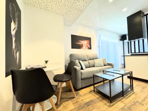 a living room with a couch and a table at Apartamentos Identia Sport by gaiarooms in León