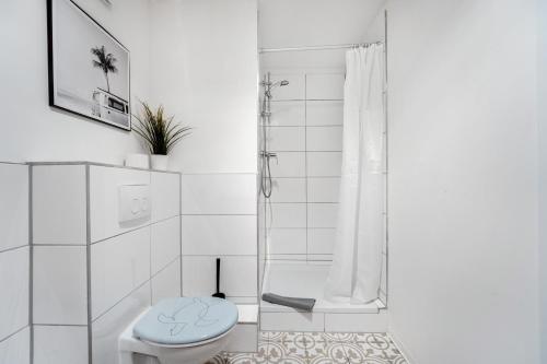biała łazienka z toaletą i prysznicem w obiekcie Moderne Wohnung mit Garten & Küche w mieście Celle