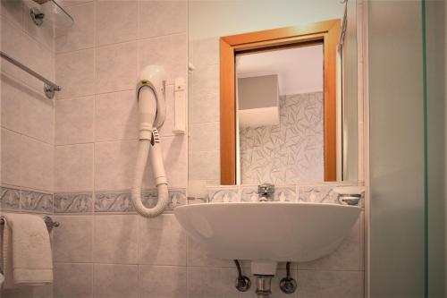 bagno con lavandino e specchio di Hotel Ombretta Mare a Rimini