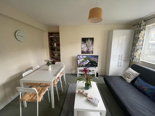 ein Wohnzimmer mit einem Sofa und einem Tisch in der Unterkunft Stunning Flat Close to Regents Park and Euston Station! in London