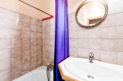 ein Badezimmer mit einer Badewanne, einem Waschbecken und einem Spiegel in der Unterkunft Chalet le Séchet - Maeva Particuliers - 2 Pièces 4 personnes Confort 140622 in Bellentre