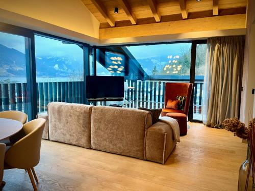 a living room with a couch and a large window at Haus am Lift in Zell am See